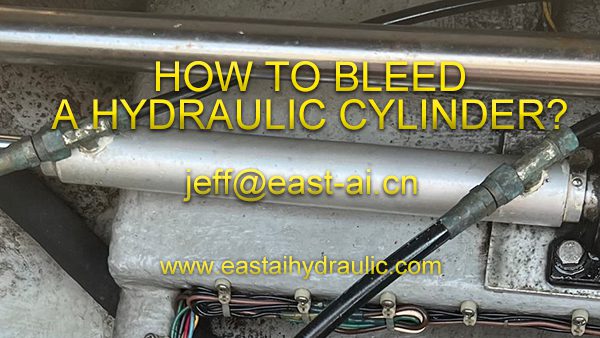 Technician bleeding a hydraulic cylinder at a workbench